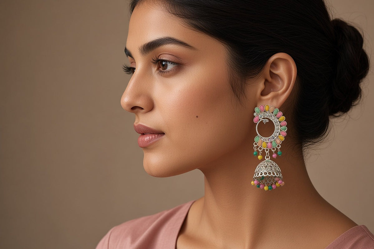 Silver chandbali jhumka earring with pastel multicolour stones worn by a model in profile