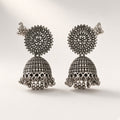 Surya oxidised silver-tone jhumkas with sunburst stud, filigree bell, ghungroo fringe and ear-chain, studio shot