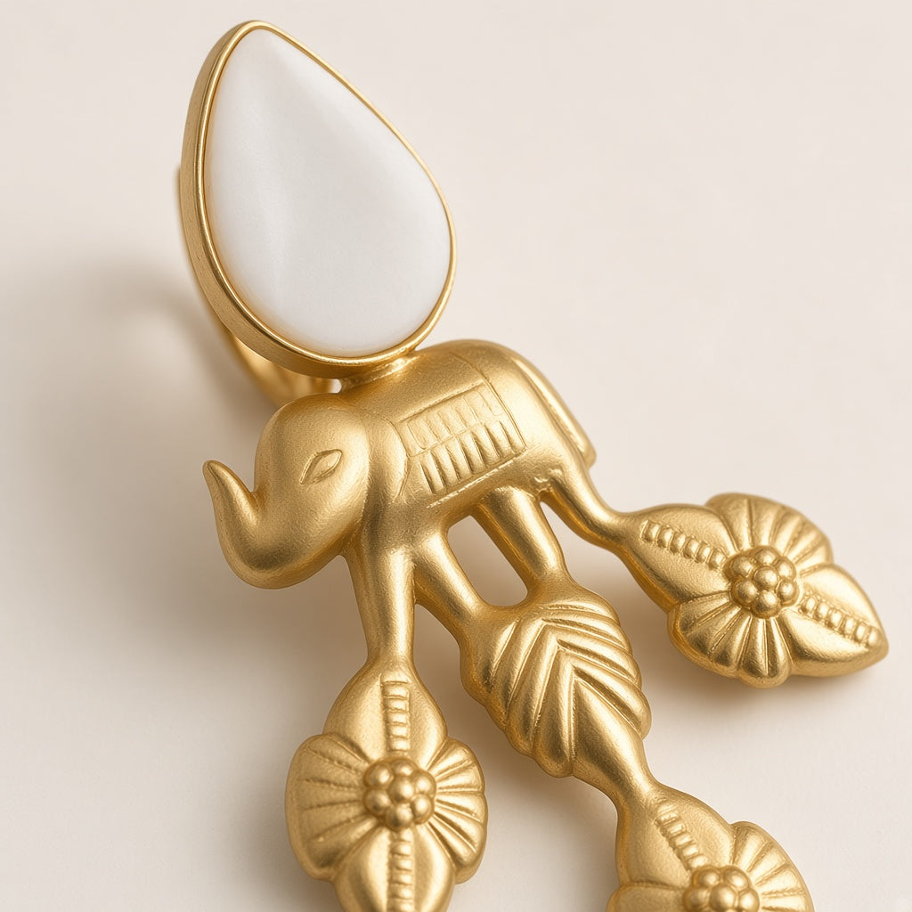 Vana earring close-up of the sculpted elephant and leaf-and-flower drops